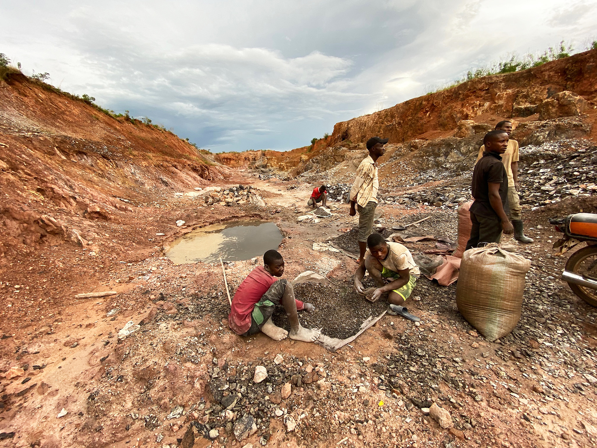 Mine artisanale de cuivre et de cobalt en RDC avec des travailleurs extrayant et triant des minerais dans une carrière à ciel ouvert.
