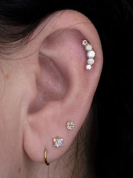 Ohr mit Helix Piercing und drei Ohrlöchern mit Piercingschmuck aus Gold von Junipurr Jewelry