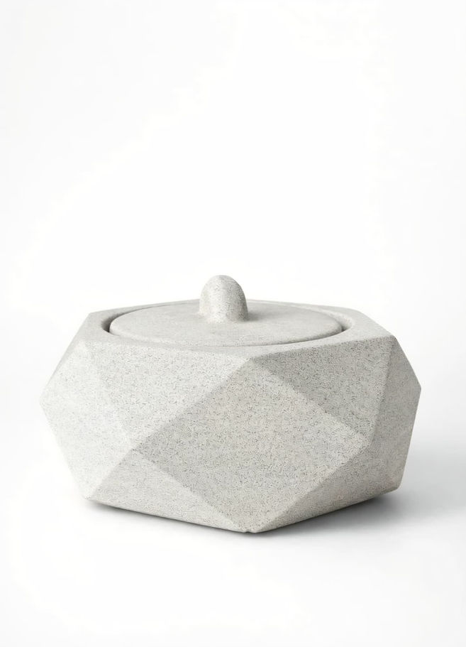 Açık gri çokgen beton kapaklı kutu, minimalist bir tasarım.