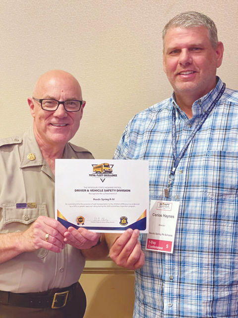 Reeds Spring Transportation Director Carlos Haynes (right) accepts the Total Fleet Excellence Award from Richard Hardgrove of the Missouri State Highway Patrol (left). (Photo submitted)