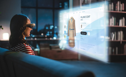 Young Woman Using Virtual Reality Headset At Home, Sitting on a Couch, Shopping Online via