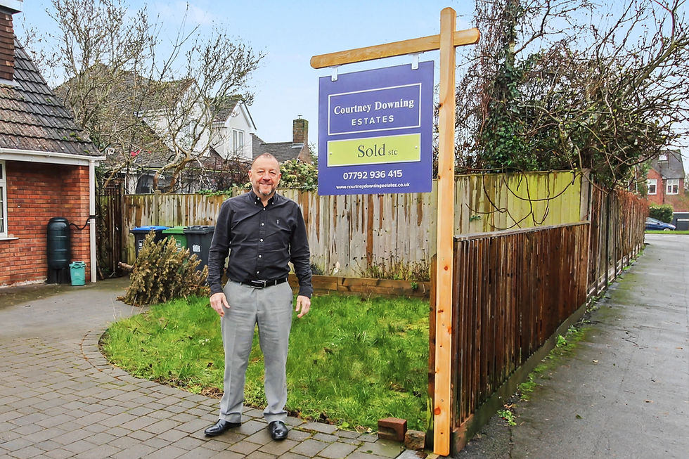 Man standing next to a sold sales board