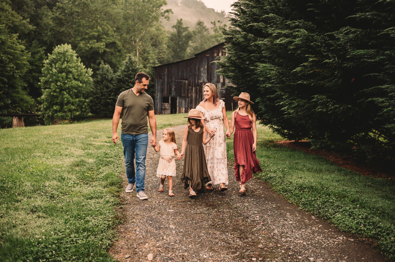 Family walking together in front of rustic barn house