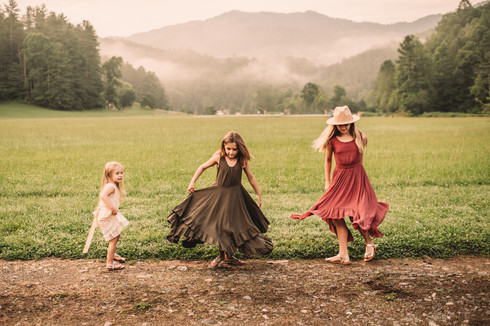 Sisters twirling in front of North Carolina mountains