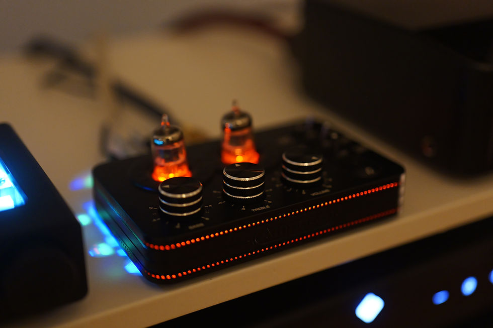 Audio device with glowing vacuum tubes and knobs on a shelf. Blue and orange lights create a warm, futuristic ambiance.