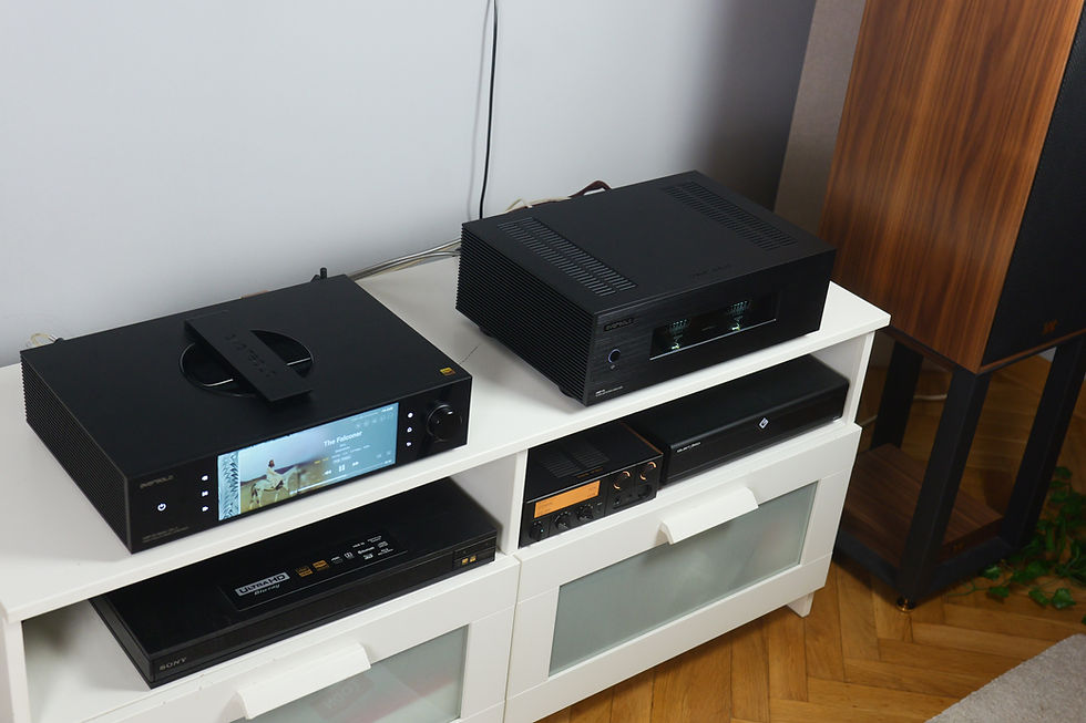 Black hi-fi components on a white media cabinet; one screen shows The Falconer. Sony Ultra HD Blu-ray player below.
