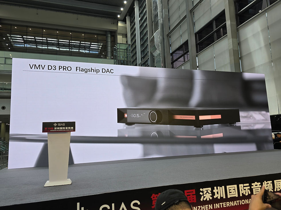 Stage with a large screen displaying VMV D3 PRO Flagship DAC. A podium is in front, set in a modern, industrial-style building.