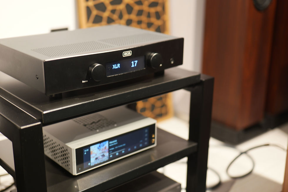 Black audio equipment on a shelf displays "XLR 17." Background features a patterned panel and wooden speaker, creating a techy ambiance.