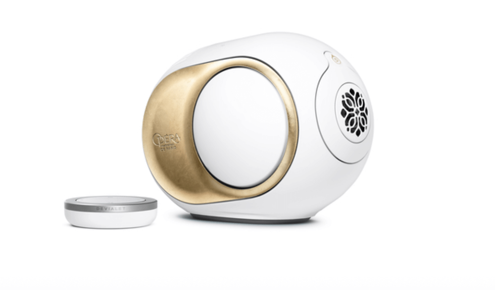White and gold spherical speaker with floral grill detail on a plain white background, branded "Opera de Paris" and "Devialet."