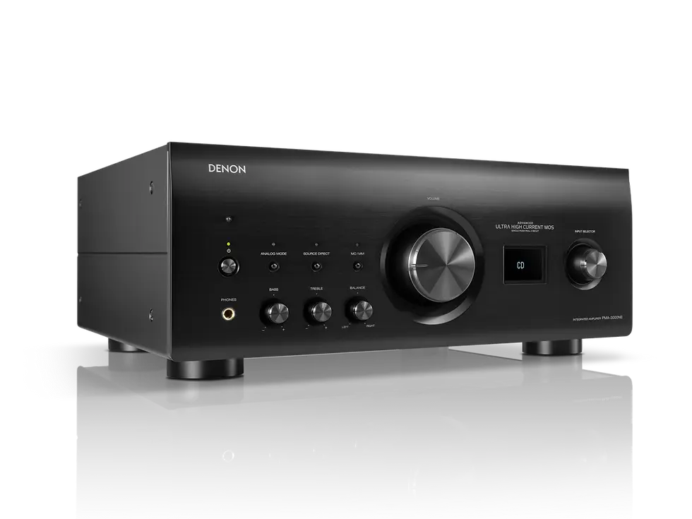 Black Denon audio amplifier with multiple knobs and a digital display reading "CD," set on a reflective surface against a plain background.