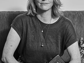 A black and white portrait of Charlotte anderson, hawjkes bay photographer holding her camera