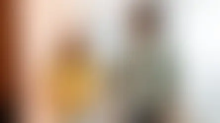 Deux collègues souriants échangeant dans un bureau, illustrant la collaboration en équipe