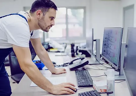 An operator monitors industrial equipment performance metrics from the control room.