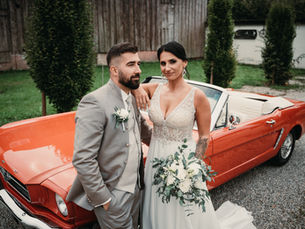 Hochzeitspaar vor einem roten Mustang Oldtimer in der Lenderstuben