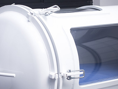 Close-up of a white HBOT hyperbaric oxygen therapy chamber