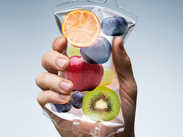 Hand holding a fruit-filled IV bag