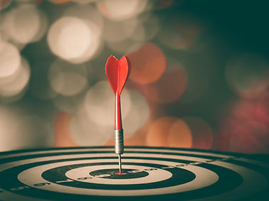 Red dart oriented vertically on a dart board bullseye