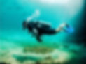 A scuba diver underwater in Casa cenote with turquoise waters