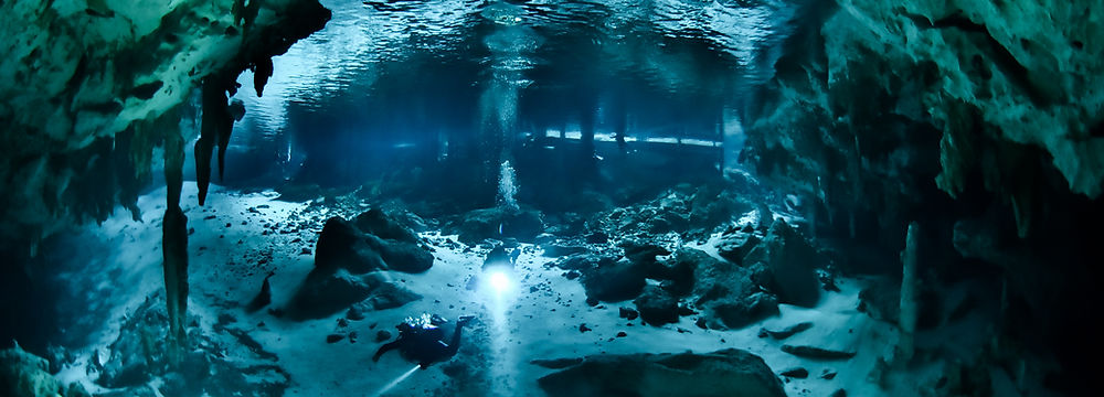 A scuba diver looking at the camera in Dos Ojos cenote
