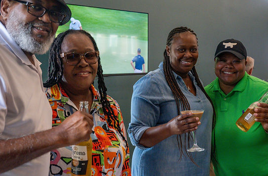 Guests smiling and holding drinks at a wedding event.