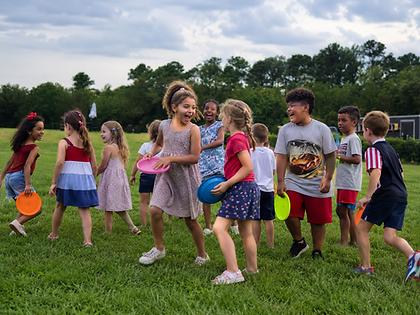 Diverse group of children playing with frisbees in a field