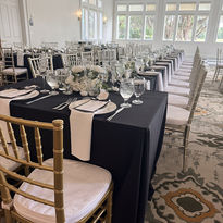 Elegant wedding reception table with black linens and gold chairs