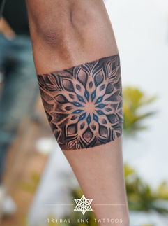 Arm with tribal mandala tattoo design, Tribal Ink Tattoos, detailed artwork.