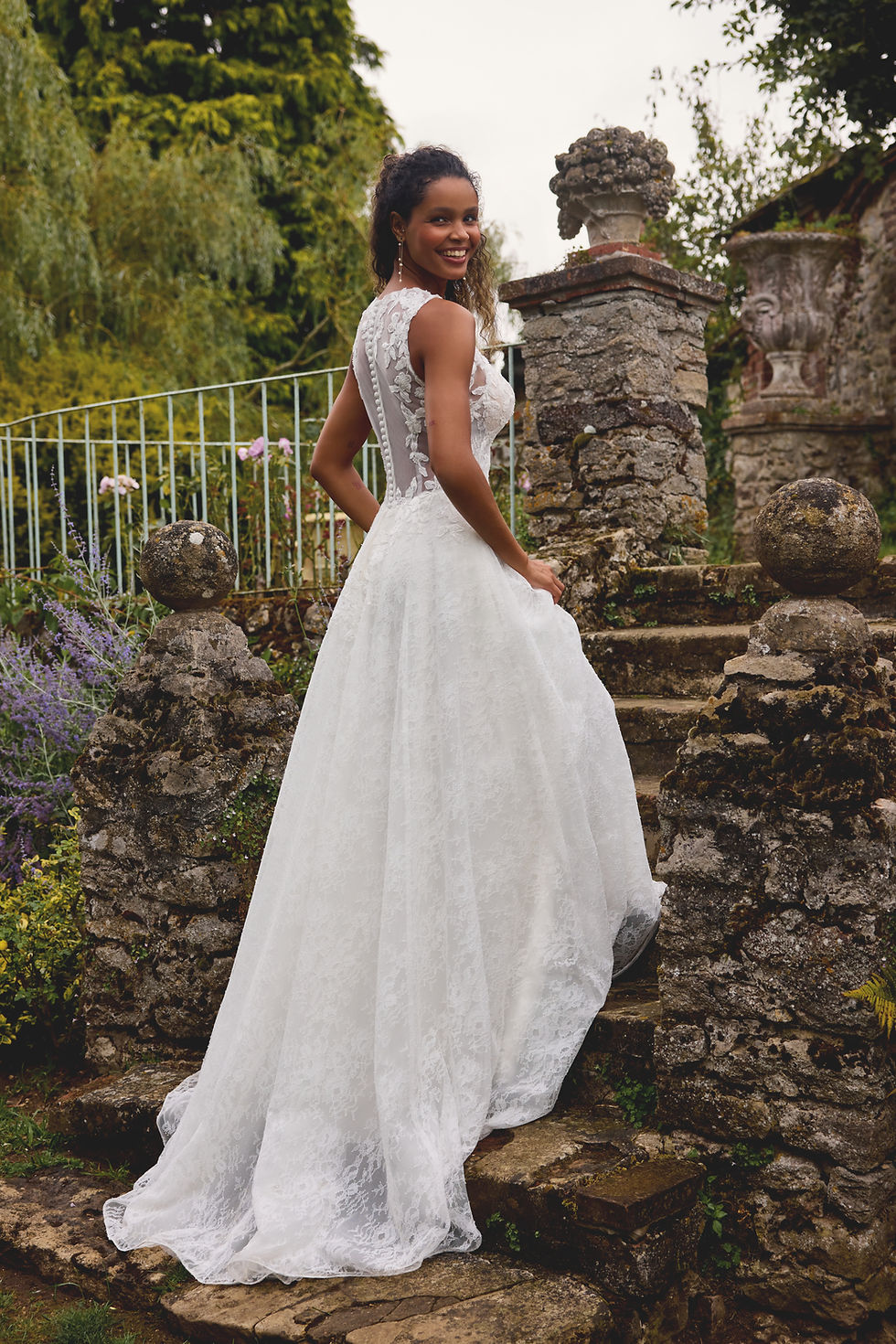 Bride in elegant lace wedding gown ascending stone steps