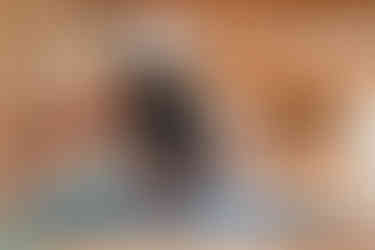 Man doing a yoga inversion on a wooden wall using straps. His arms are outstretched behind him, hands linked.