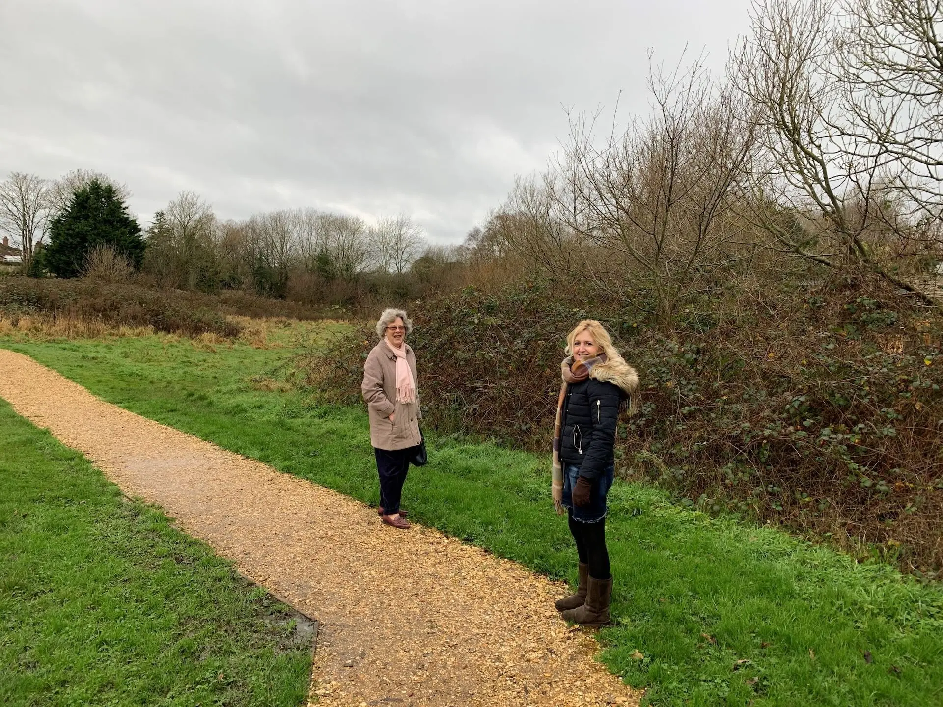 Two women stood in a field with a winding path