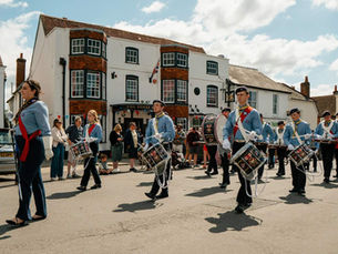 Scout Cadet Band performing in a parade in a village