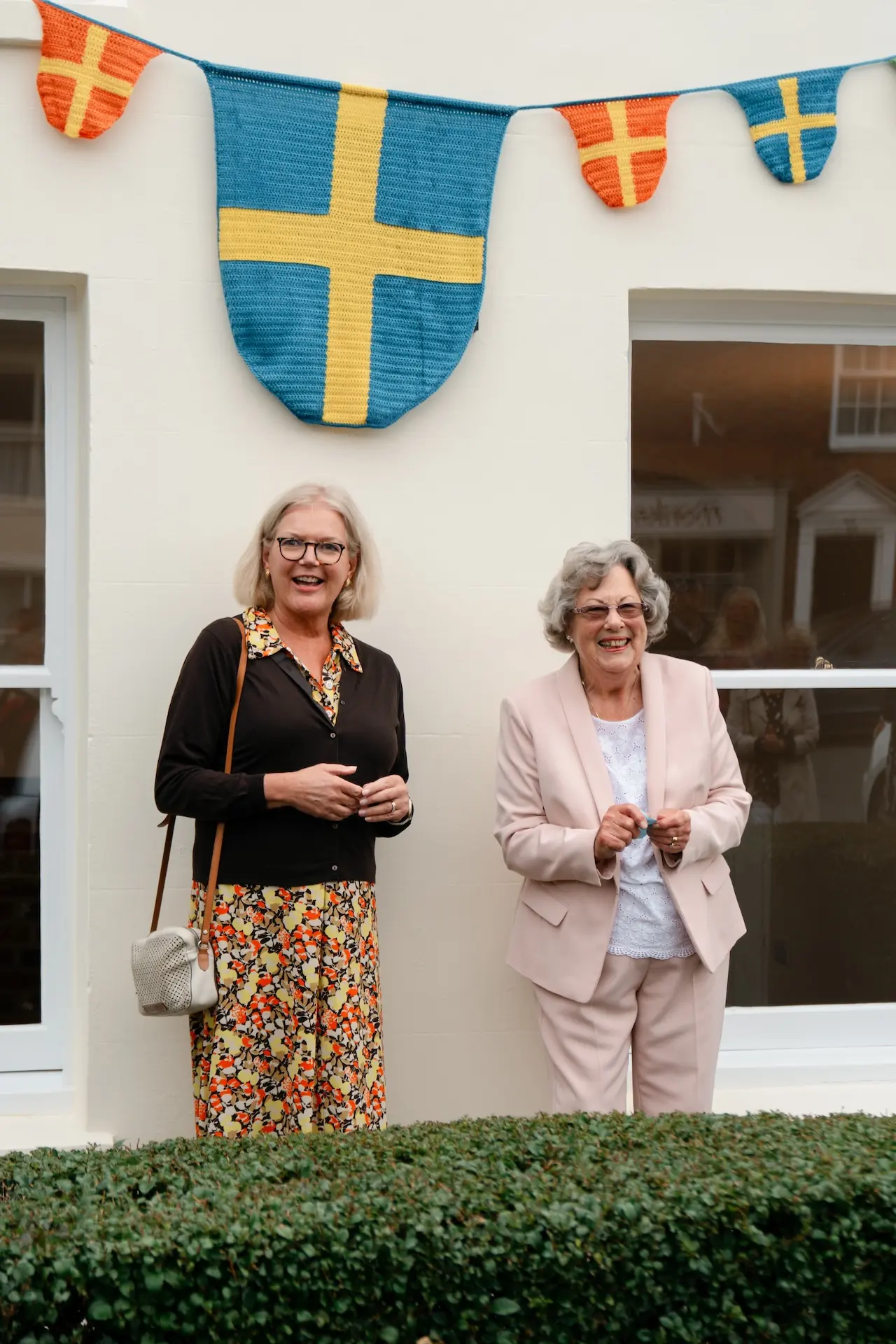 Two people stood in front of house and bunting