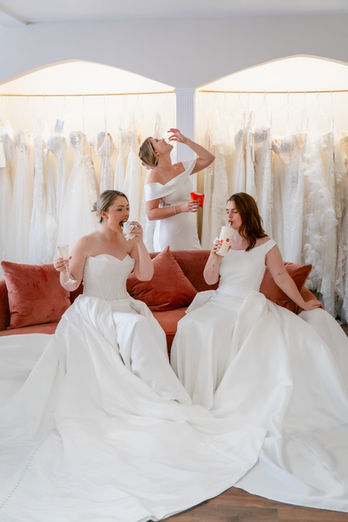 Three women in wedding dresses celebrating