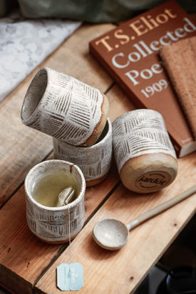 Ceramic cups, tea, wooden spoon, and T.S. Eliot poetry book