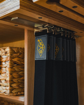yoga wall straps hanging in a wooden cubby.