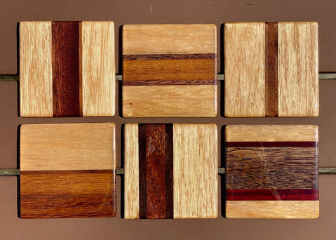 Zes vierkante houten onderzetters met verschillende houtsoorten en ontwerpen, close-up Yuri's Houtwerk