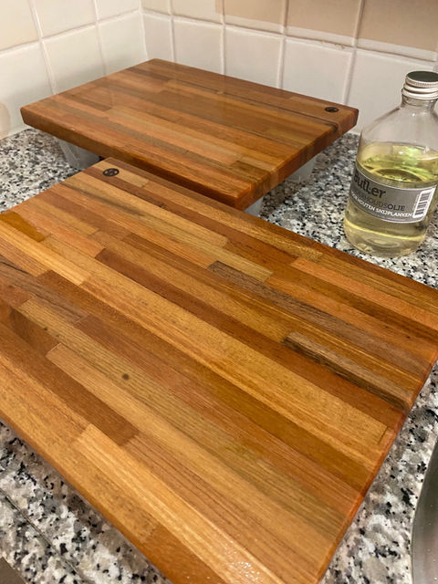 Twee houten snijplanken op een aanrecht, met een fles mineraal olie. Yuri's Houtwerk
