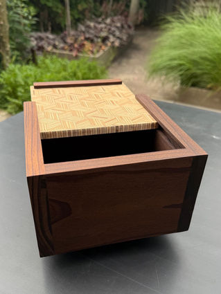 Houten doos met open deksel. Doosje van kebony Yuri's Houtwerk staat buiten.