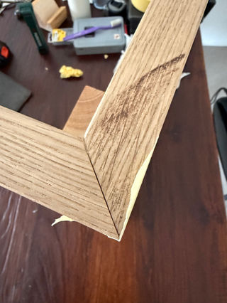 Houten hoek verbinding met beschadiging. Close-up op een donkere tafel.