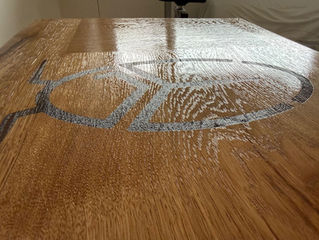 Eiken Houten plank met close up van gelaserd logo op een houten plank net in de lak gezet. Yuri's Houtwerk