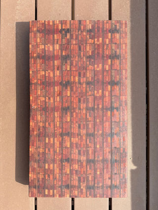 Foto van snijplank hardhout met veel verschillende kleine blokjes en verschillende kleuren