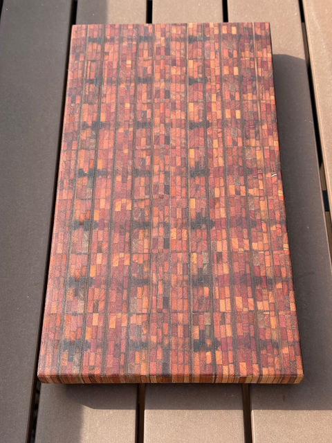 Foto van snijplank hardhout met veel verschillende kleine blokjes en verschillende kleuren