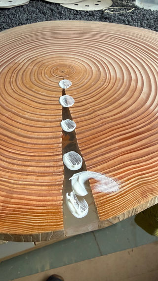 Ronde houten borrelplank met jaarringen, transparante epoxy en witte polijst pasta.