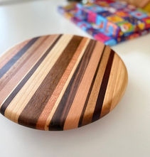 Ronde houten plank van hergebruikt hout met diagonale strepen.