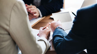 Business professionals reviewing commercial contracts and purchase orders during negotiation meeting.