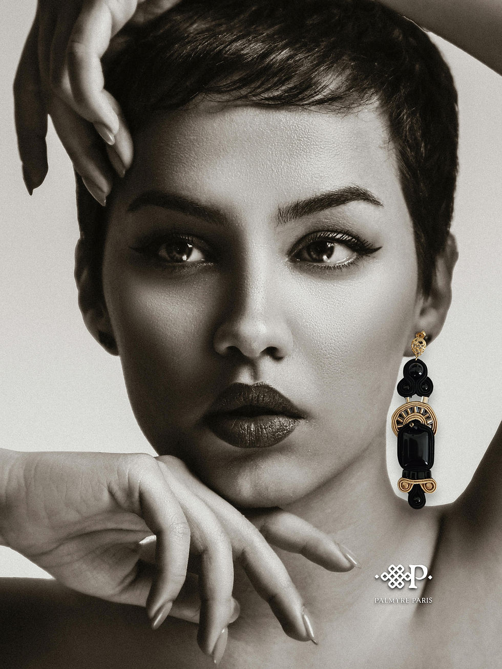 Boucles d’oreilles Nadia Nocturne portées, leur noir profond et leurs détails or mat contrastant avec un portrait en noir et