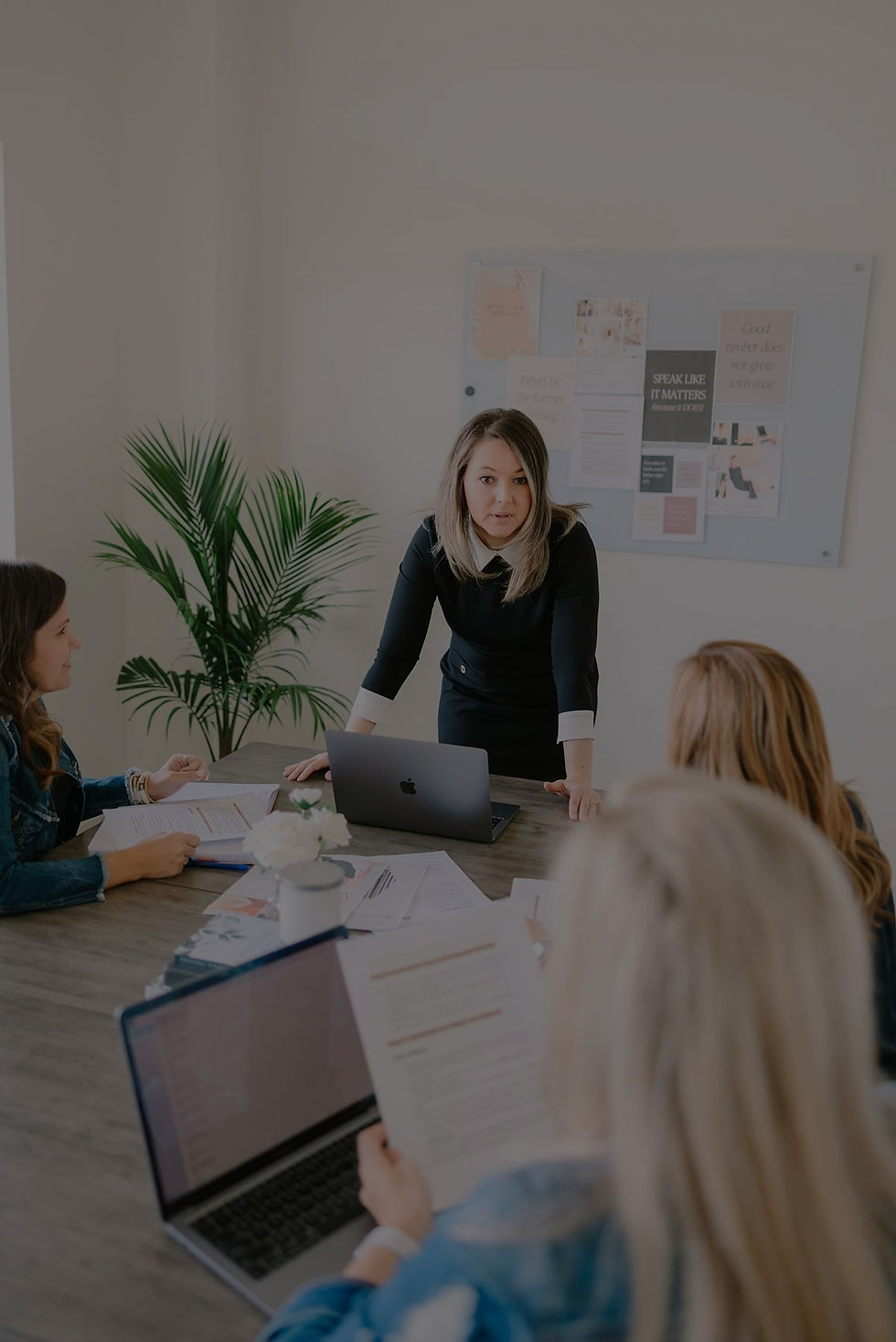 Woman presenting information to a team using a whiteboard during a meeting