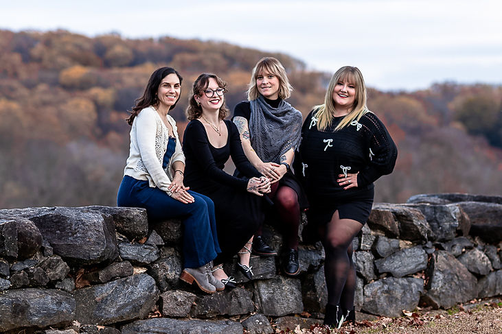 Four women standing outside in front of a wall
