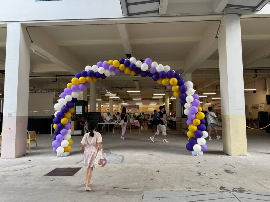 Purple, yellow and white balloon archway at a school