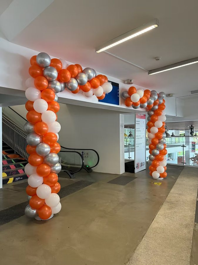 Balloon Door Frame: orange, white and silver balloons framing a doorway